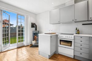 a kitchen with white appliances and a large window at JECI Apartment - Spacious & Central Jessheim in Gystad