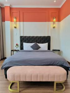 a bedroom with a bed with an orange and white wall at RL Boutique Dalat in Da Lat