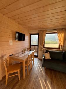 ein Esszimmer mit Tisch und Couch in der Unterkunft Gospodarstwo agroturystyczne U Gazdy in Wisła