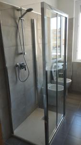 a bathroom with a glass shower with a toilet at Appartamento Delfino Blu in Porto Torres