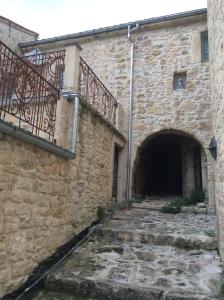 un edificio de piedra con puerta y balcón en Casa Vacanza Abruzzo 06804dueAFFzerozerozerodue, en Caramanico Terme