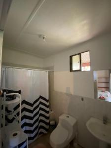 a bathroom with a toilet and a sink at Tumu Cabin Rapa Nui in Hanga Roa