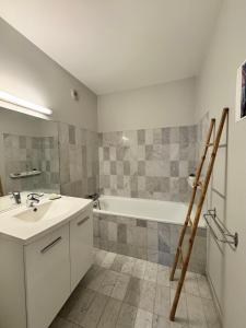 a bathroom with a sink and a bath tub at Le Nantais, centre de Rennes avec garage privé in Rennes