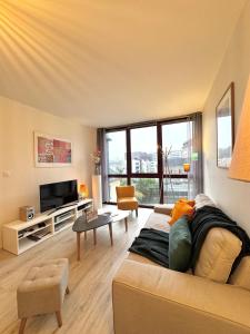 a living room with a couch and a tv at Le Nantais, centre de Rennes avec garage privé in Rennes