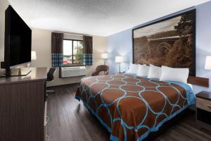 una camera d'albergo con un letto e una TV a schermo piatto di Super 8 by Wyndham Summersville - New River National Park a Summersville