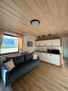 a living room with a blue couch and a kitchen at Gospodarstwo agroturystyczne U Gazdy in Wisła +42 photos