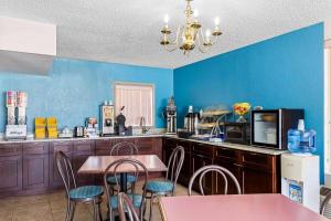 a kitchen with blue walls and tables and chairs at Days Inn by Wyndham Clayton in Clayton