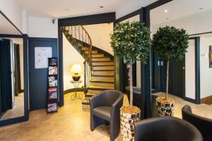 a lobby with stairs and chairs and a staircase at Élysée Hôtel in Châteauroux
