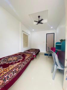 Un dormitorio con dos camas y un ventilador de techo. en Nagaon Homestay, en Nowgong
