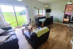 a living room with a couch and a table with chairs at Hartcliffe Retreat in Penistone