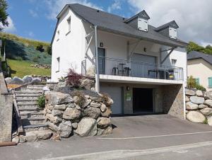 ein großes weißes Haus mit einer Steinwand in der Unterkunft Eden des Pyrénées in Arcizans-Avant
