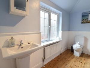 une salle de bain avec un lavabo et des toilettes dans l'établissement 18 Chamberlaine Road, à Weymouth 23 autres photos