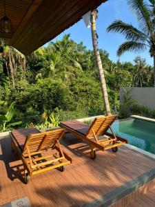 a patio with two chairs and a table next to a pool at Villa Pondok Utu, Ubud - Bali in Ubud