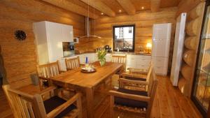a kitchen with a wooden table and wooden chairs at Holzhaus Usedom mit moderner Ausstattung SAUNA und Kamin in Karnin (Usedom)