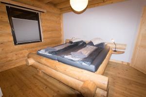 a bed in a log room with a window at Holzhaus Usedom mit moderner Ausstattung SAUNA und Kamin in Karnin (Usedom)