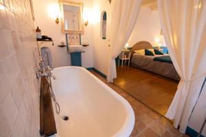 un bagno con vasca e una camera da letto con un letto di Le Clos du Barry a Sévérac-lʼÉglise