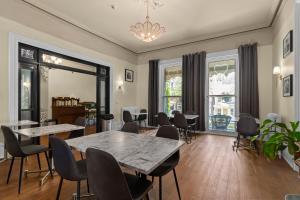 a living room with tables and chairs and windows at Hochelaga Inn in Kingston