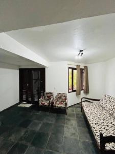 a living room with two beds and a window at Casa pé na areia praia Garopaba in Garopaba