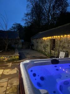 a jacuzzi tub in a yard at night at Stewards Granary in Cornhill-on-tweed