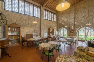 a large room with tables and chairs and windows at Agriturismo Santa Croce in San Gimignano