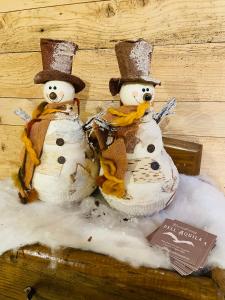two snowmen sitting next to each other in snow at Residenza dell'Aquila - appartamento in Vezza dʼOglio