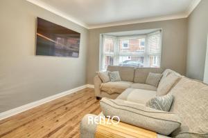 a living room with a couch and a window at Incredible and Charming 4-bed Home in Lincoln by Renzo, Free Parking, Close to Lincoln Hospital! in Lincoln