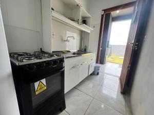 a kitchen with a stove and a sink at Tranquilidade e água fresca! in Tramandaí