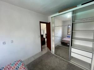a room with a glass closet with a mirror at Tranquilidade e água fresca! in Tramandaí +38 photos