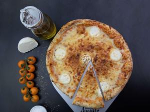 a pizza sitting on top of a table next to a bottle of beer at ibis Paris Montmartre Sacré-Coeur in Paris