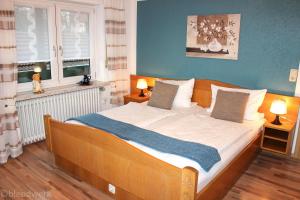 - une chambre avec un grand lit et un mur bleu dans l'établissement Pension Weigert, à Bodenmais