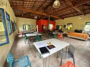 a large room with tables and chairs and a couch at Guararema Espaço e Pousada Krisalys in Jacareí