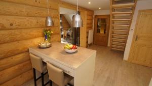 a kitchen with a table with a bowl of fruit on it at Holzhaus Usedom mit moderner Ausstattung SAUNA und Kamin in Karnin (Usedom) +13 photos