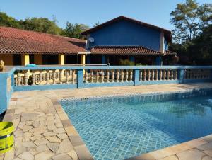 a swimming pool with a fence next to a house at Guararema Espaço e Pousada Krisalys in Jacareí