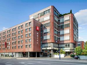 ein rotes Backsteingebäude an der Ecke einer Straße in der Unterkunft Ibis Ulm City in Ulm