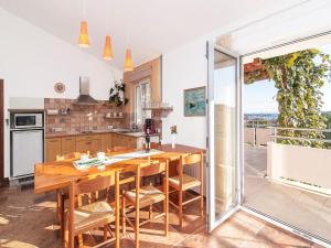 a kitchen with a wooden table and a balcony at Apartments Ceja near sea in Medulin