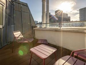 a balcony with two chairs and a bench on a building at Mercure Paris Place d'Italie in Paris