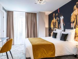 a hotel room with a large bed and a table at Mercure Paris Place d'Italie in Paris