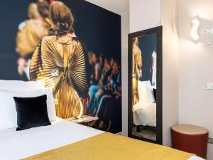 a bedroom with a poster of a woman in a dressing room at Mercure Paris Place d'Italie in Paris