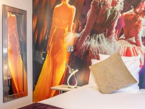 a bedroom with a bed and a poster of a woman at Mercure Paris Place d'Italie in Paris