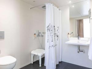 a white bathroom with a toilet and a sink at Mercure Paris Place d'Italie in Paris