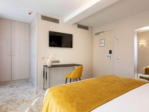 a hotel room with a bed and a desk at Mercure Paris Place d'Italie in Paris