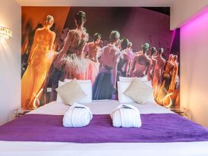 a bedroom with a bed with a large poster of models at Mercure Paris Place d'Italie in Paris