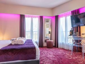 a bedroom with a bed with pink lighting at Mercure Paris Place d'Italie in Paris