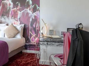 a bedroom with a bed and a table with a fireplace at Mercure Paris Place d'Italie in Paris