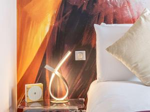a bed with a night stand next to a bed with a pillow at Mercure Paris Place d'Italie in Paris