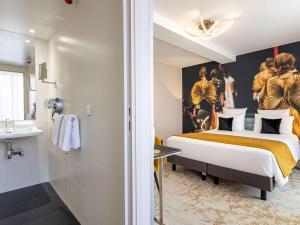 a hotel room with a bed and a bathroom at Mercure Paris Place d'Italie in Paris