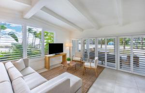 a living room with a white couch and a tv at Islander Resort in Islamorada