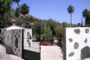 a gate in a garden with palm trees at Casa Rosiana in Santa Lucía +13 photos
