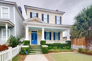 a white house with a blue door and a fence at Anderson Place in Savannah