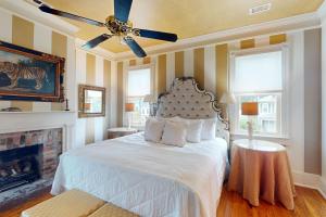a bedroom with a bed with a ceiling fan and a fireplace at Anderson Place in Savannah